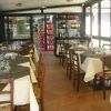 Ristorante con tavoli apparecchiati e scaffali di vini.
