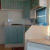 Cucina compatta con mobili verdi, piano cottura e lavello.