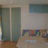 Soggiorno di una casa mobile con tavolo, divano colorato e pensili verdi.